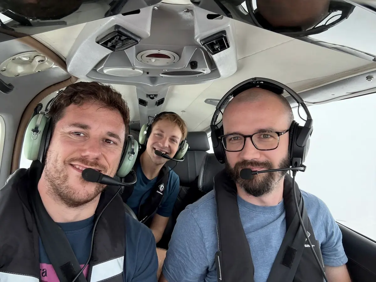 Three teammates in headsets in a light aircraft