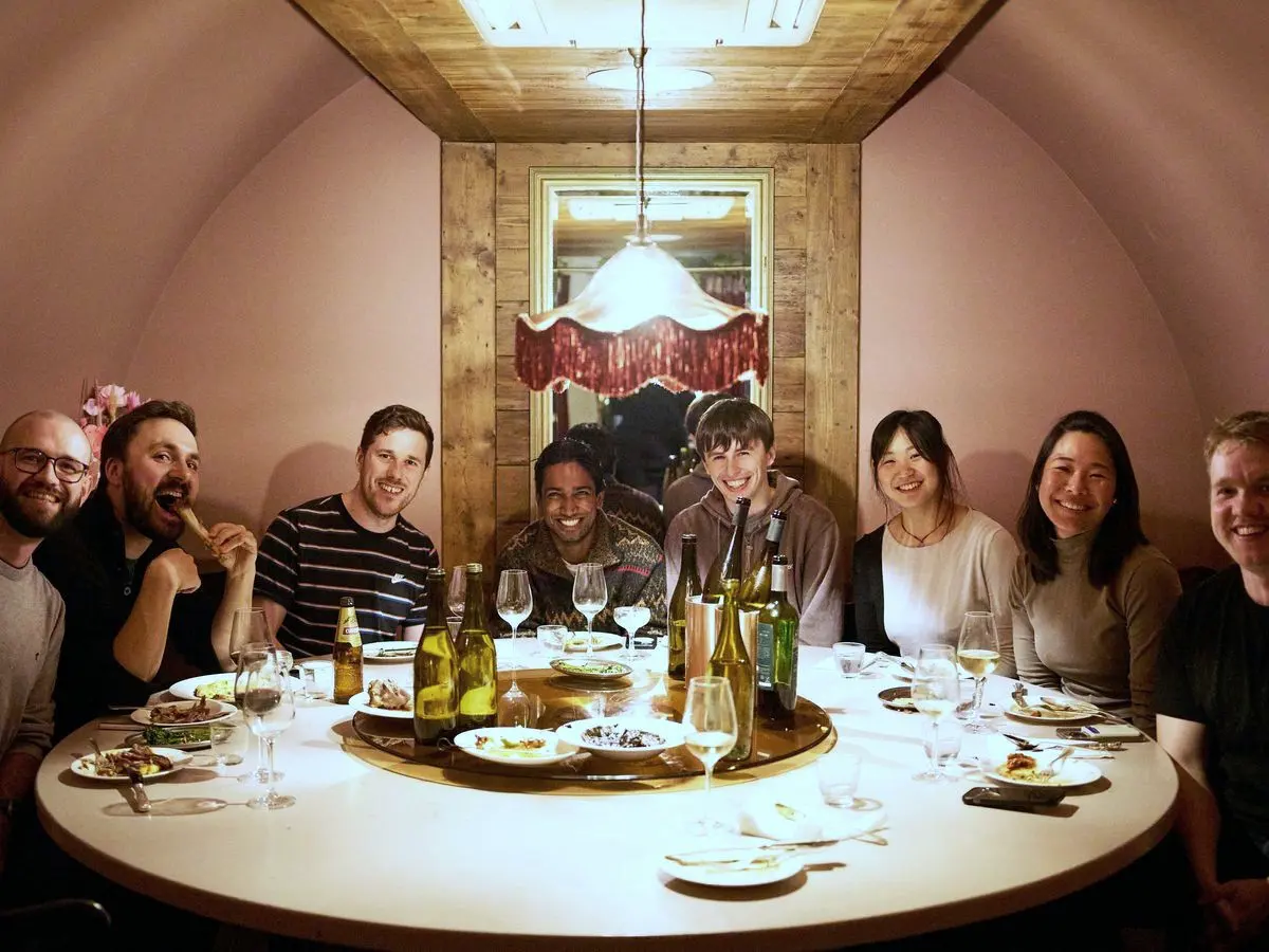 Nine teammates around a table at a team dinner