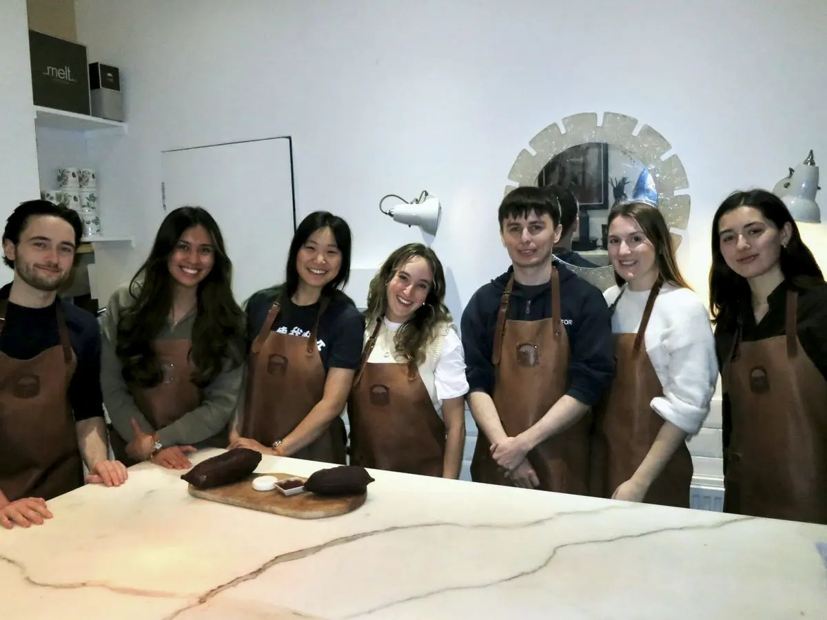 Seven teammates in aprons at a workshop